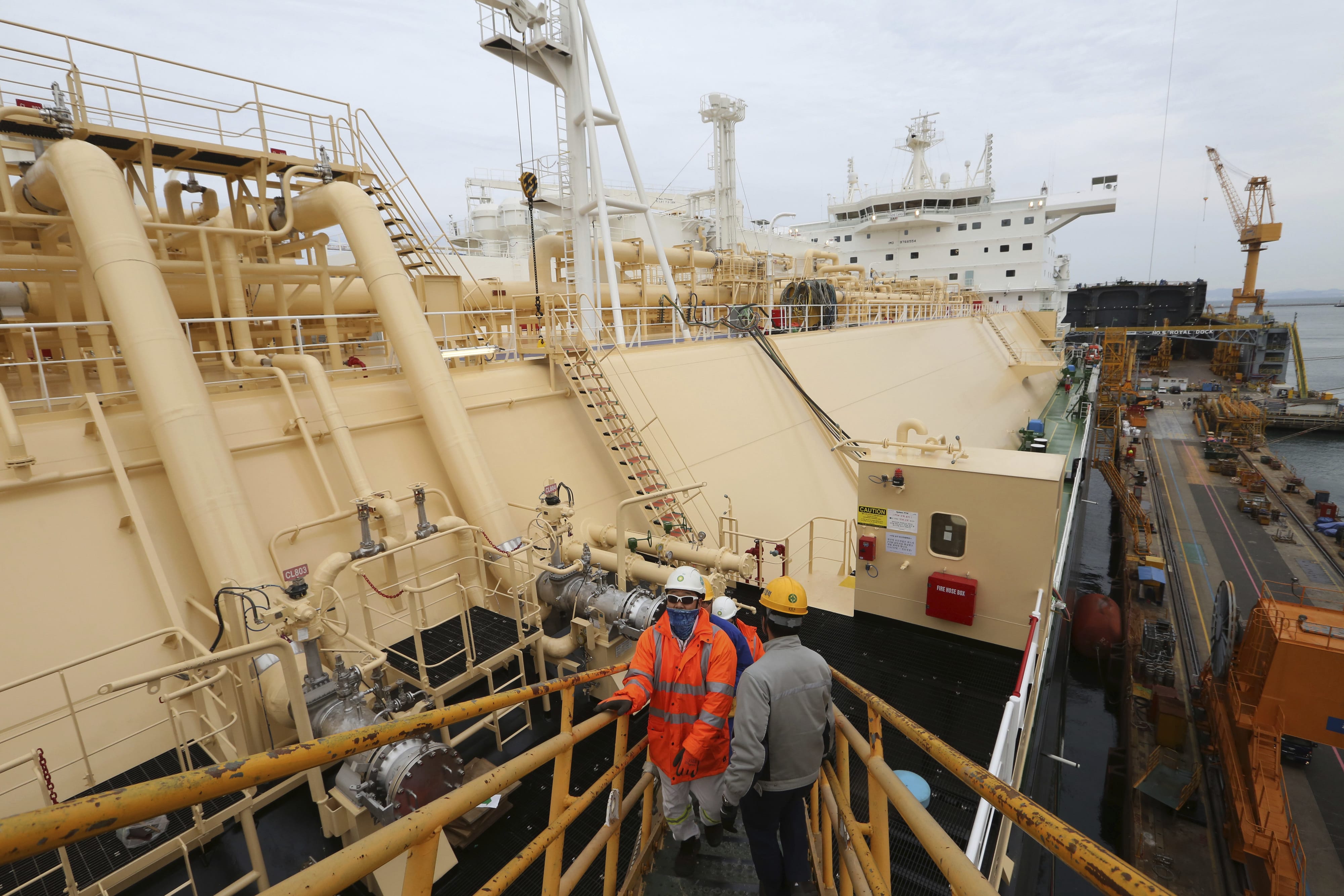 In this Dec. 7, 2018 photo, workers board large-sized liquified natural gas carriers under construction at the Daewoo Shipbuilding and Marine Engineering facility on Geoje Island, South Korea.The boom in fossil-fuel production in the United States has been matched by a rush on the other side of the Pacific to build the infrastructure needed to respond to the seemingly unquenchable thirst for energy among Asia’s top economies. (AP Photo/Ahn Young-joon)